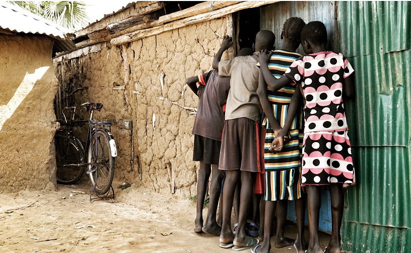 Children peeking makeshift movie theatre Nyal South Sudan.