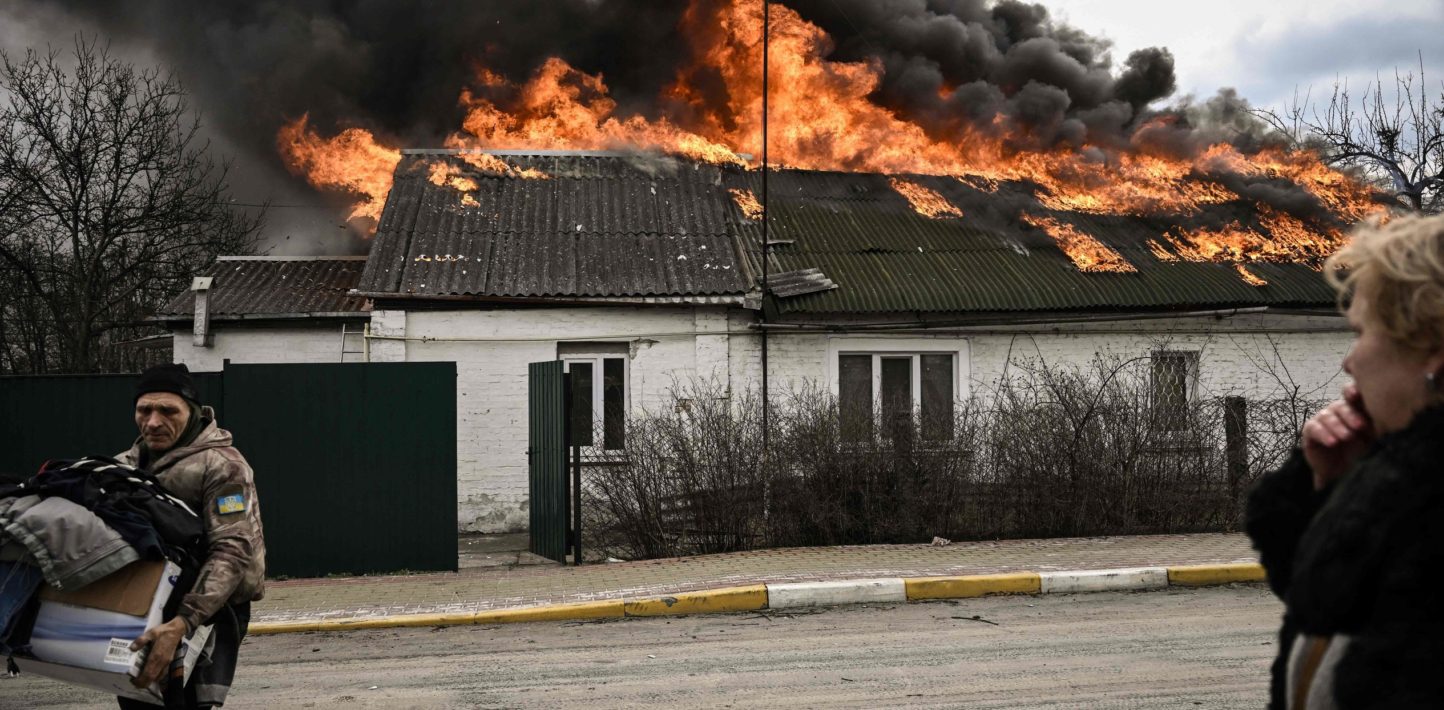 A man removes personal belongings from a burning house after being shelled in the city of Irpin, outside Kyiv, on March 4, 2022.