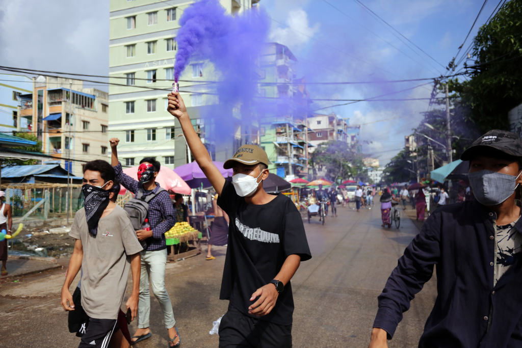 A young demonstrator lights a flare during an anti-coup protest in Yangon, Myanmar onÂ May 16, 2022. (