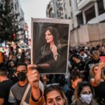 A protester holds a portrait of Mahsa Amini during a demonstration in support of Amini, a young Iranian woman who died after being arrested in Tehran by the Islamic Republic's morality police,